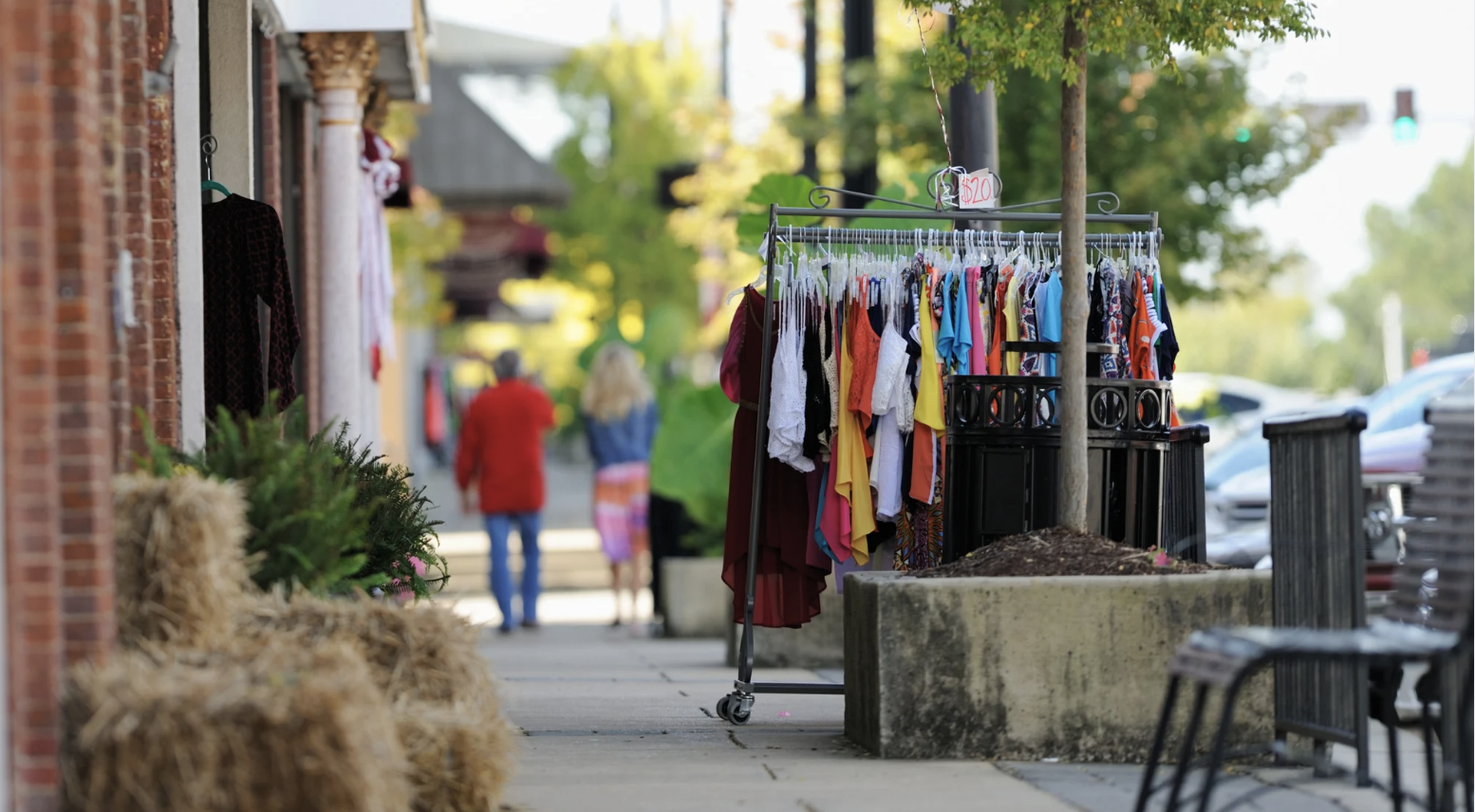 downtown sidewalk scene with clothing rack and sale sign